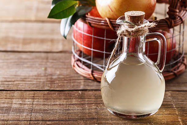 istock Apple cider vinegar over rustic wooden background 624498336