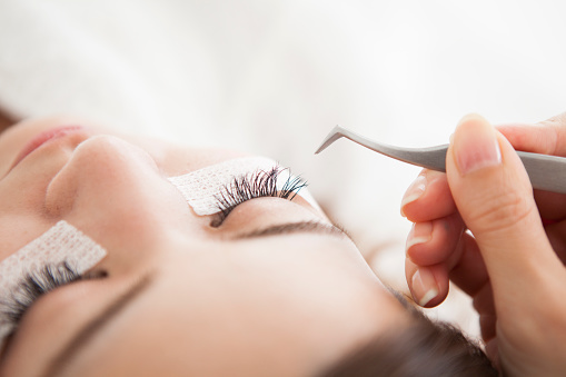 Woman planting lashes with eyelashes at a salon