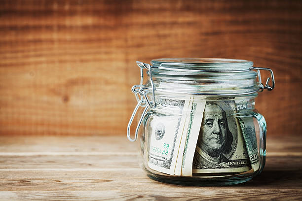 istock Dollar bills in jar on rustic table. Saving money concept. 624511488