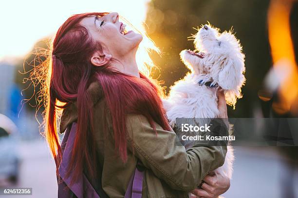 Photo libre de droit de Jolie Fille Rousse Et Chiot Blanc Souriant Ensemble banque d'images et plus d'images libres de droit de Chien