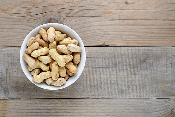 istock Roasted peanuts in bowl on wooden background 624529120