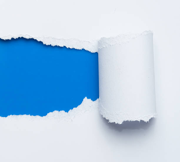 istock ripped white paper over blue background 624529252