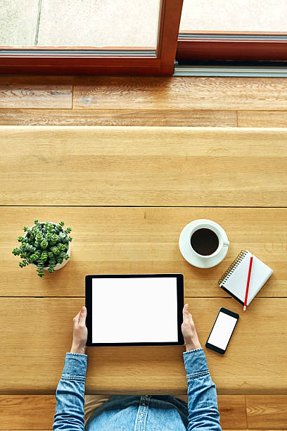 istock Hipster using digital tablet by smartphone, book, coffee and plant 624529634