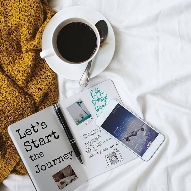 Morning coffee in bed with daily planner and mobile