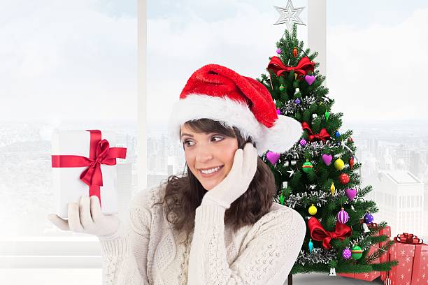 istock Excited woman in santa hat looking at gift box 624531100