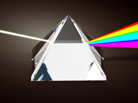 Crystal prism dividing white light into rainbow color tones.