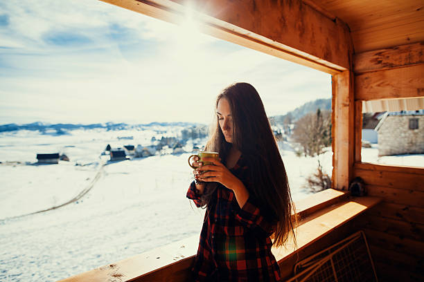 istock girl drinks tea on winter terrace 624539832