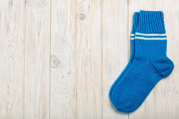 istock Knitted wool socks blue on light wooden background. 624540836