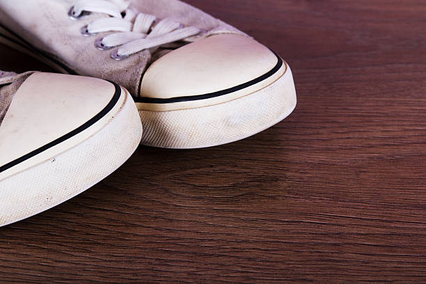 istock Old canvas shoes on a wooden floor 624542760