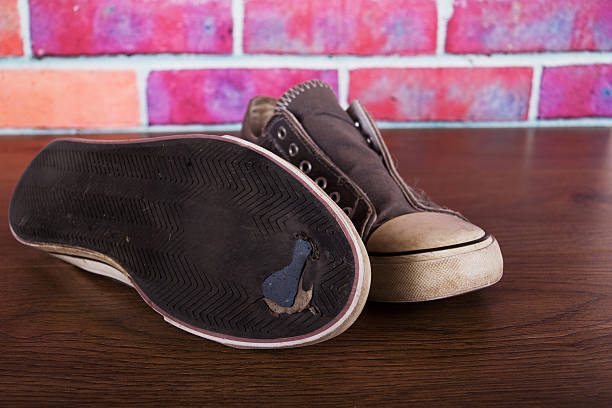 istock Old canvas shoes on a wooden floor 624542792