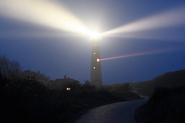 phare de schiermonnikoog dans les dunes pendant une nuit brumeuse - dark light beam beacon projection photos et images de collection