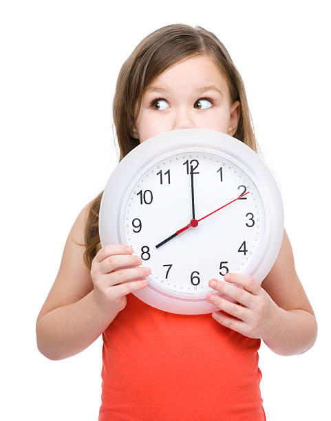 Little girl is holding big clock stock photo