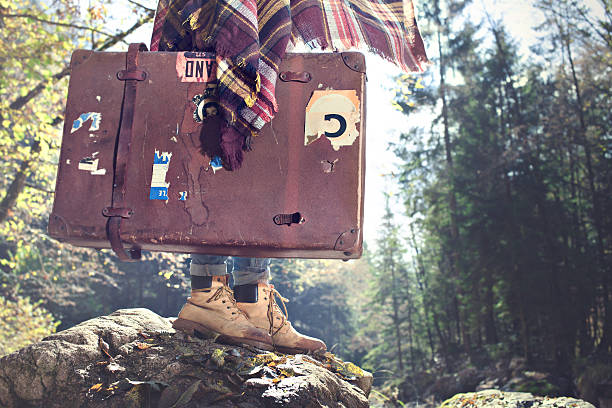 istock hipster woman walks with her suitcase in the forest 624545214