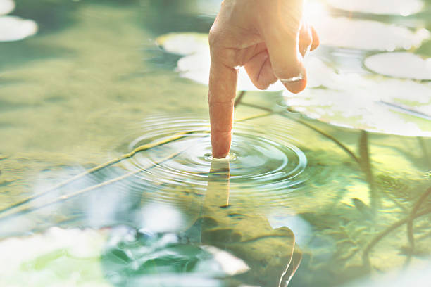 persona tocca l'acqua con la mano - light touch foto e immagini stock