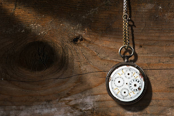 Broken Pocket Watch on Wooden Background Old and vintage pocket watch with chain and without watch hands on a wooden background with copy space broken pocket watch stock pictures, royalty-free photos & images