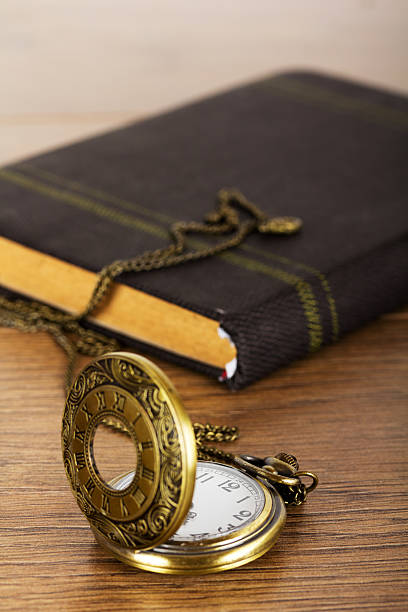 istock Pocket watch and book against a rustic background 624569148