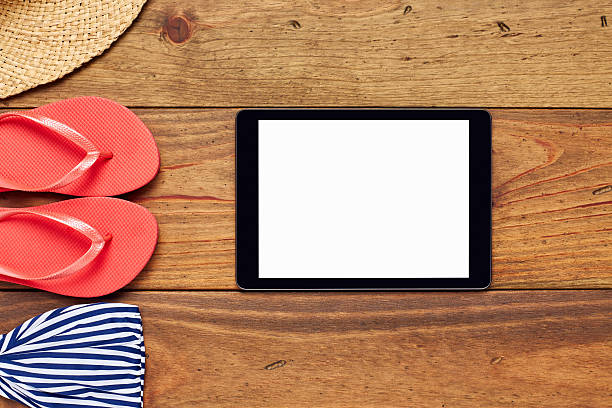 istock Flat lay of tablet computer by sunhat, flip-flop and bikini 624569472