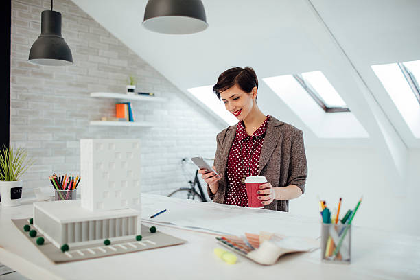 istock Female Architect Texting On Smart Phone In Her Office. 624570222