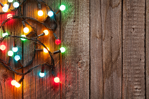 Christmas colorful lights on wooden table with copy space