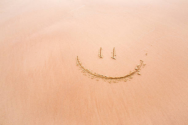 istock Soft smile drawn on wet sand by the waves. Background. 624593040
