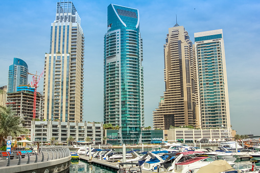 Dubai, United Arab Emirates - May 2, 2013: views of Dubai Marina skyscrapers and motorboats docked at Pier 7.