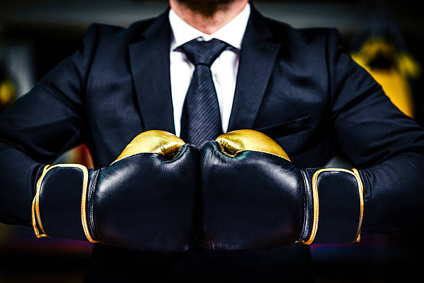 hombre de negocios con guantes de boxeo está listo para la batalla corporativa. - boxing caucasian men business fotografías e imágenes de stock