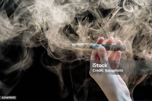 Woman Smoking Electronic Cigarette On Background Stockfoto en meer beelden van Elektronische sigaret - Elektronische sigaret, Damp van e-sigaret, Sigaret