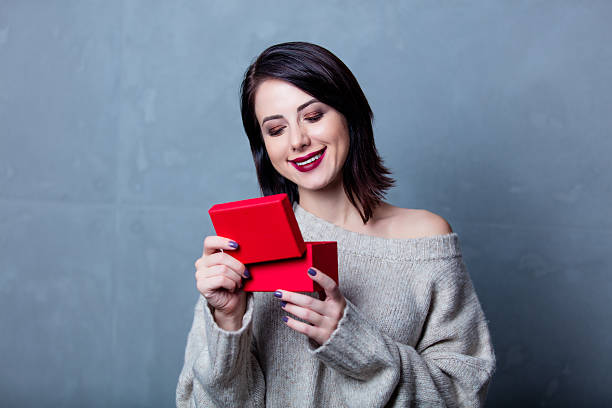 istock woman with little red gift box 624619942
