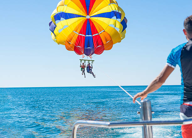 happy couple parasailing in dominicana beach in summer - parasailing stok fotoğraflar ve resimler