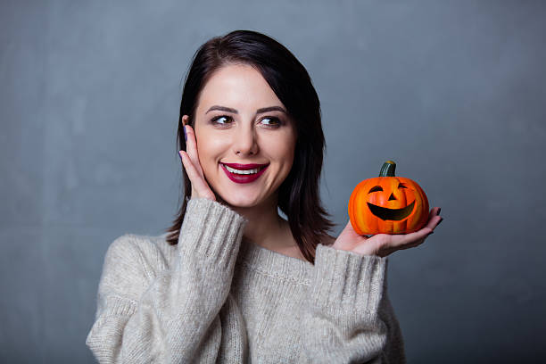 istock woman with halloween pumpkin 624626130