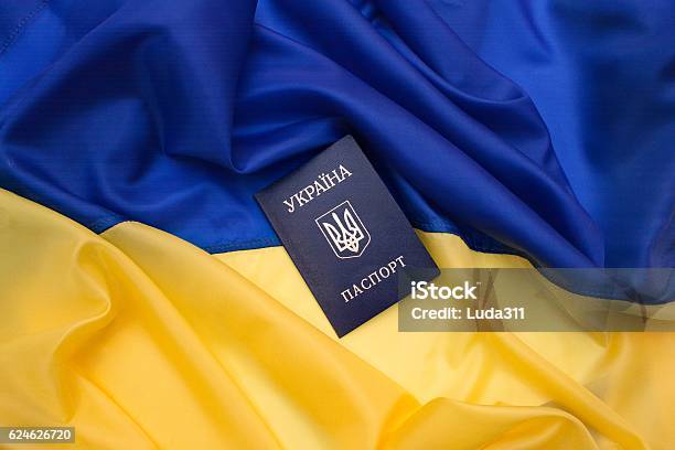 Pasaporte Ucraniano En La Bandera De Ucrania Foto de stock y más banco de imágenes de Ucrania - Ucrania, Pasaporte, Bandera