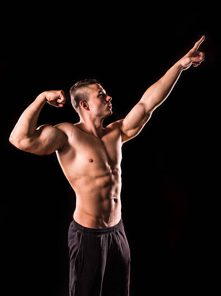 istock young bodybuilder man pointing isolated on black background 624631298