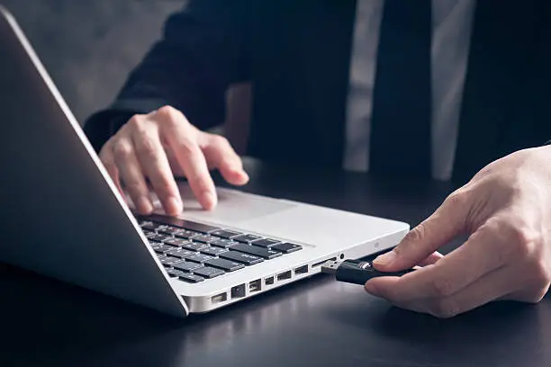 Photo of Businessman using flash drive connect to laptop
