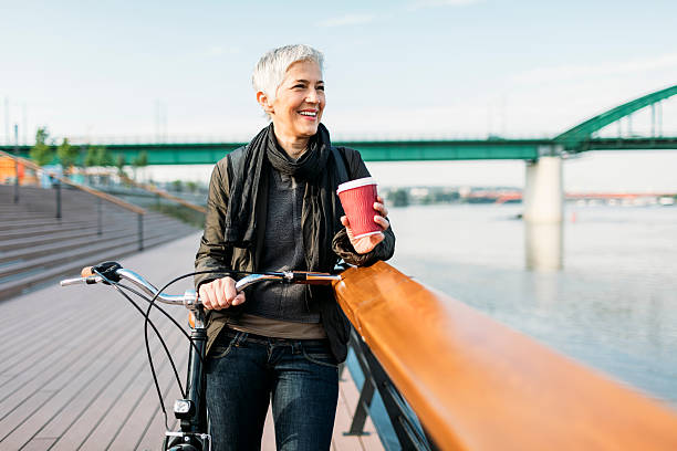 istock Mature Woman Standing On The Rivereside And Drinking Coffee. 624643742