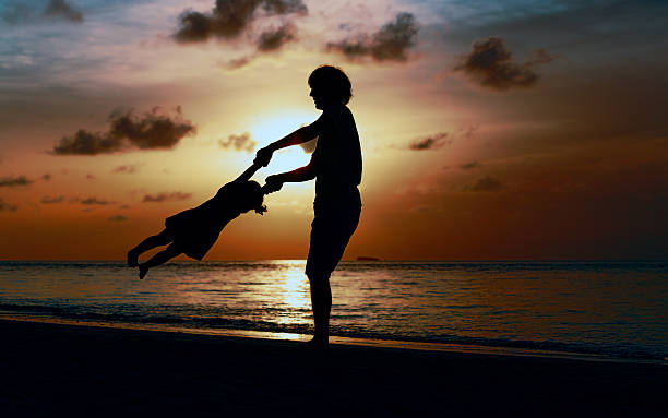 istock Father and little daughter playing silhouettes at sunset 624645998