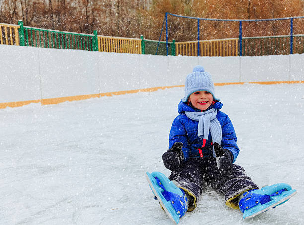 istock cute little boy learning to skate in winter 624655548