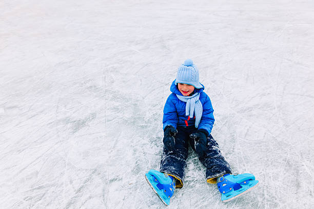 istock cute little boy learning to skate in winter 624655662