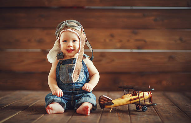 istock funny baby boy pilot aviator with airplane laughing 624670588