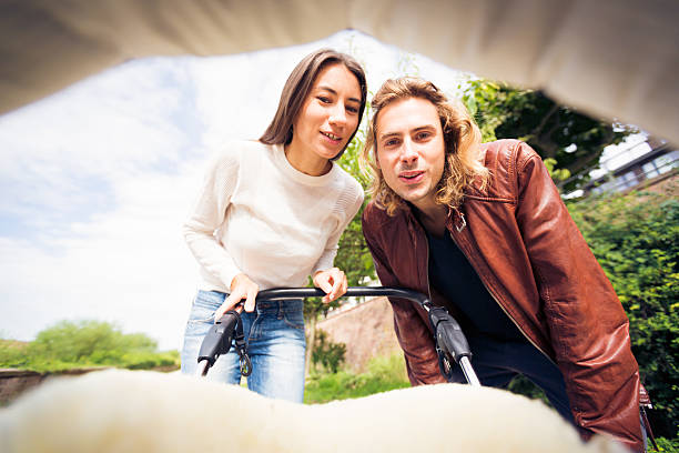 istock Young parents looking at their baby in a stroller 624671194