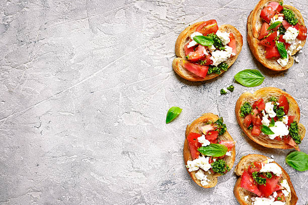 bruschetta italiana con tomates, feta y pesto de albahaca en . - bread cheese bruschetta canape fotografías e imágenes de stock