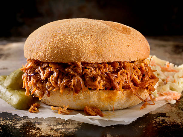 Pulled Pork Sandwich in a Savoury BBQ Sauce with Coleslaw Pulled Pork Sandwich in a Savoury BBQ Sauce with Coleslaw - Photographed on Hasselblad H3D2-39mb Camera Pulled Pork stock pictures, royalty-free photos & images
