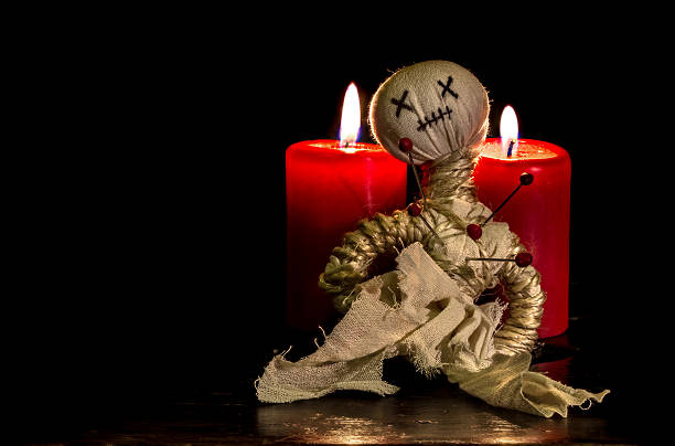 Voodoo doll in Advent Voodoo doll with needles and two burning candles revenge photos stock pictures, royalty-free photos & images