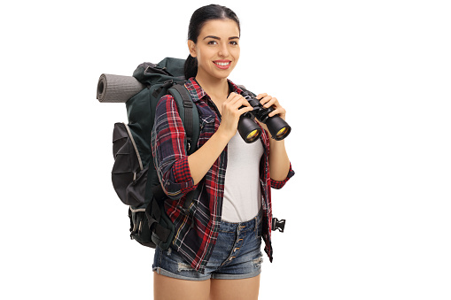 Happy female hiker holding a binoculars isolated on white background