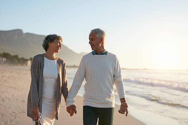 istock Loving senior couple strolling together on the beach 624682774