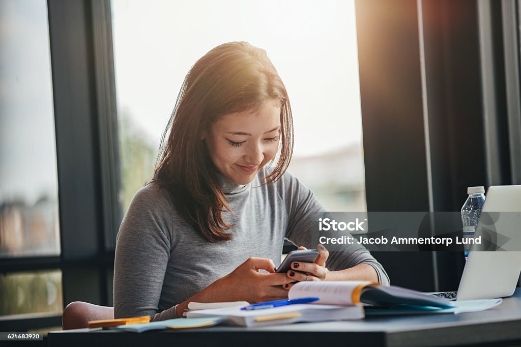 Asiatische Mädchen mit Handy in der Bibliothek - Lizenzfrei Universitätsstudent Stock-Foto