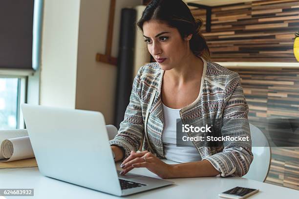 Junge Frau Arbeitet In Ihrem Büro Stockfoto und mehr Bilder von Geschäftsfrau - Geschäftsfrau, Laptop, Frauen