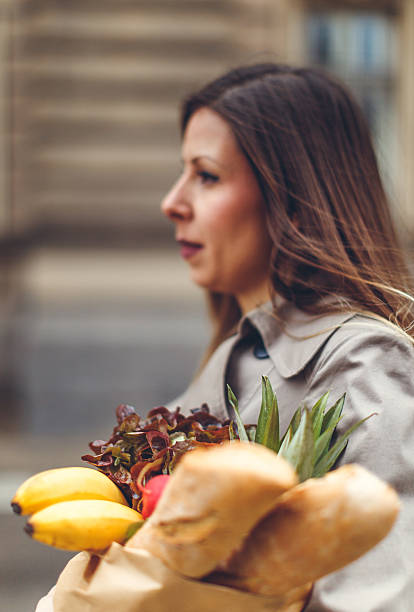 istock Young woman carrying groceries 624684964