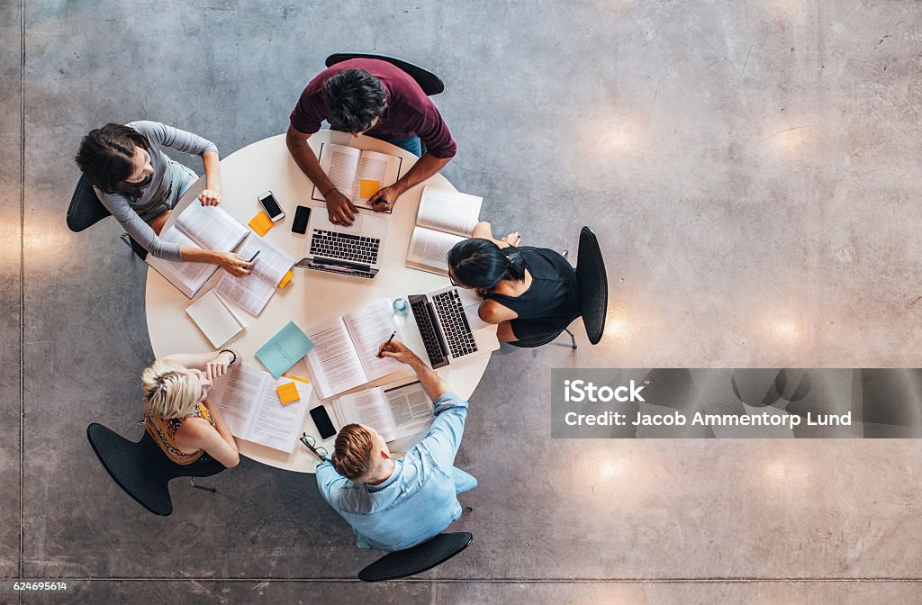 University students doing group study Top view of group of students sitting together at table. University students doing group study. Group Of People Stock Photo