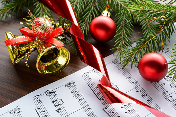 christmas decorations on the sheets with notes - şarkı söylemek stok fotoğraflar ve resimler
