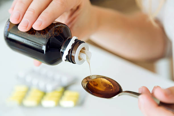 istock Young woman taking medicine on spoon at home. 624700504